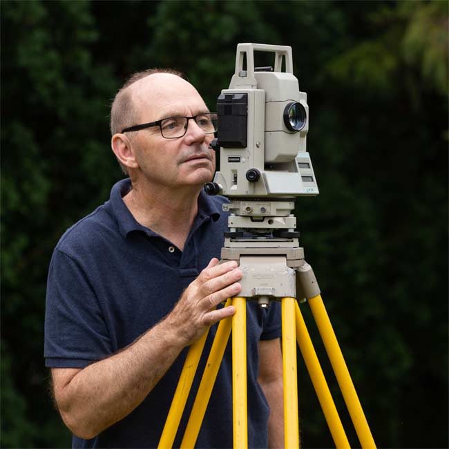 Paul Roggeman with his land surveying intrument.